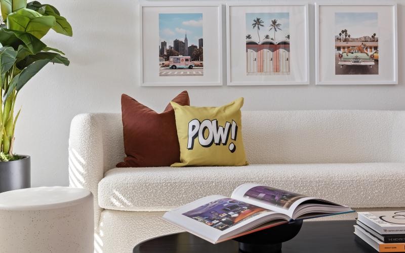 a white couch with a table and a coffee table with a plant